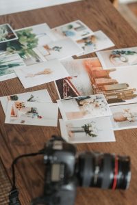 Printed photos scattered on wooden table, showcasing print quality and sample work.