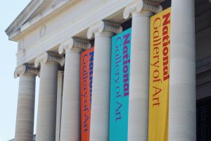 Large museum banners on stone columns capturing attention quickly with vibrant colors.