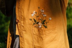 Floral embroidery above a shirt pocket, applying guidelines to specialty garments.