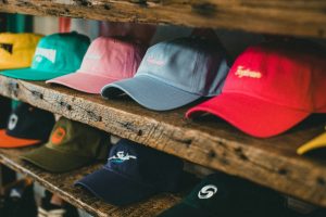 Colorful hats displayed on wooden shelves, focusing on smart hat logo placement