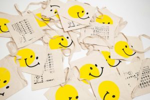 Pile of custom printed smiley tote bags that deliver long-term marketing value
