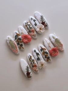 Handmade fabric hair clips featuring embroidered floral details and 3D textured flowers.